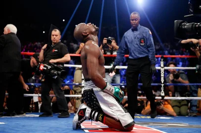 LAS VEGAS, NV - SEPTEMBER 12: Floyd Mayweather Jr. kneels on the mat after winning his WBC/WBA welterweight title fight against Andre Berto at MGM Grand Garden Arena on September 12, 2015 in Las Vegas, Nevada. Mayweather won the fight by unanimous decision.   Ezra Shaw/Getty Images/AFP