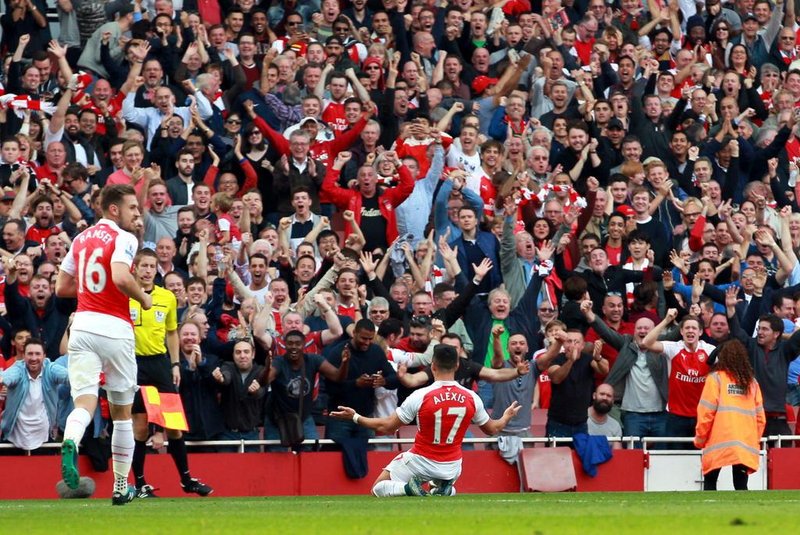 Arsenals Chilean striker Alexis Sanchez (2L) celebrates his first goal during the English Premier League football match between Arsenal and Manchester United at the Emirates Stadium in London on October 4, 2015.    AFP PHOTO / IKIMAGESRESTRICTED TO EDITORIAL USE. No use with unauthorised audio, video, data, fixture lists, club/league logos or live services. Online in-match use limited to 45 images, no video emulation. No use in betting, games or single club/league/player publications.