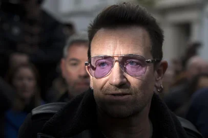 U2 frontman Bono arrives at a west London studio to record the new Band Aid 30 single on November 15, 2014. Bob Geldof, One Direction, Bono and some 30 other stars gathered in a studio in London on Saturday to record a 30th anniversary version of the Band Aid charity single to raise money to fight Ebola. Led Zeppelins Robert Plant, Coldplays Chris Martin and Sinead OConnor were also among the rockers brought together by Geldof to sing the fourth version of Do They Know Its Christmas? Musicians began arriving in the early morning and were expected to record all day and into the night before the single is aired for the first time on Sunday and then officially released on Monday. AFP PHOTO / ANDREW COWIE