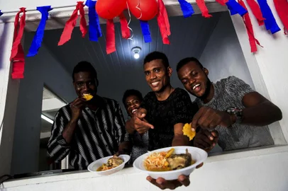 PORTO ALEGRE, RS, BRASIL, 30-12-2017: Os haitianos Esteevy Mc Fleury Joseph, Roselaure Michel, Guetty Dorcelian e Oles Blanc. Um grupo de imigrantes se reúne em uma casa de festas na zona norte de Porto Alegre para preparar a celebração de Ano Novo. Eles cozinham pratos típicos do país e o espaço recebe decoração nas cores das bandeiras do Haiti e do Brasil. (Foto: Mateus Bruxel / Agência RBS)