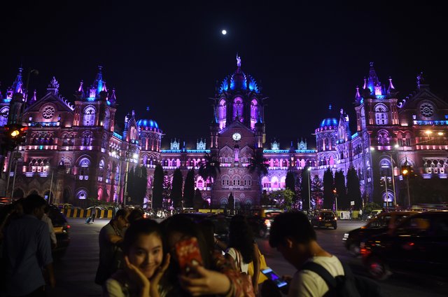 Indianos na frente da estação de trem Chhatrapati Shivaji Terminus (CST) antes das celebrações da véspera de Ano Novo em Mumbai em 31 de dezembro de 2017. Indianos na frente da estação de trem Chhatrapati Shivaji Terminus (CST) antes das celebrações da véspera de Ano Novo em Mumbai em 31 de dezembro de 2017.