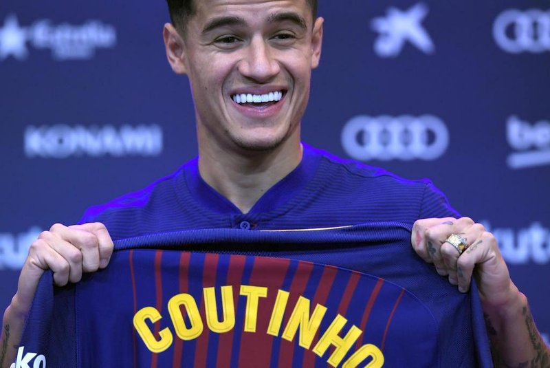 Barcelonas new Brazilian midfielder Philippe Coutinho shows his new jersey before holding a press conference in Barcelona on January 8, 2018. Philippe Coutinho officially joined Barcelona today, completing a move from Liverpool thought to be worth 160 million euros ($192 million), making it the third richest transfer in history. / AFP PHOTO / LLUIS GENE