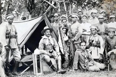  Túlio Piva, garoto com 8 anos (atrás do caule da árvore), num acampamento maragato durante a Revolução de 1923.