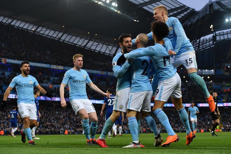 Manchester Citys Portuguese midfielder Bernardo Silva (C) celebrates with tammates scoring the opening goal during the English Premier League football match between Manchester City and Chelsea at the Etihad Stadium in Manchester, north west England on March 4, 2018. / AFP PHOTO / Anthony Devlin / RESTRICTED TO EDITORIAL USE. No use with unauthorized audio, video, data, fixture lists, club/league logos or live services. Online in-match use limited to 75 images, no video emulation. No use in betting, games or single club/league/player publications.  / 