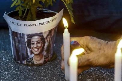An elderly man lights a candle during a rally against the murder of Brazilian councilwoman and activist Marielle Franco, in Sao Paulo Brazil on March 15, 2018.Brazilians mourned for the Rio de Janeiro councilwoman and outspoken critic of police brutality who was shot in the city center in an assassination-style killing on the eve.  / AFP PHOTO / Miguel SCHINCARIOL