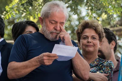  Brazilian ex-president (2003-2011) Luiz Inacio Lula da Silva (L) gestures next to Brazilian former president (2011-2016) Dilma Rousseff after attending a Catholic Mass in memory of his late wife Marisa Leticia, at the metalworkers union building in Sao Bernardo do Campo, in metropolitan Sao Paulo, Brazil, on April 7, 2018.Brazils election frontrunner and controversial leftist icon said Saturday that he will comply with an arrest warrant to start a 12-year sentence for corruption. I will comply with their warrant, he told a crowd of supporters. / AFP PHOTO / NELSON ALMEIDAEditoria: WARLocal: São Bernardo do CampoIndexador: NELSON ALMEIDASecao: crisisFonte: AFPFotógrafo: STF