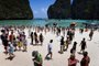  This photo taken on April 9, 2018 shows Thai park rangers keeping watch as tourists walk along the Maya Bay beach, on the southern Thai island of Koh Phi Phi.Across the region, Southeast Asia's once-pristine beaches are reeling from decades of unchecked tourism as governments scramble to confront trash-filled waters and environmental degradation without puncturing a key economic driver. / AFP PHOTO / Lillian SUWANRUMPHA / TO GO WITH AFP STORY "THAILAND-INDONESIA-PHILIPPINES-TOURISM-ENVIRONMENT" by Lillian SUWANRUMPHA with Joe FREEMANEditoria: FINLocal: Ban Ko Phi PhiIndexador: LILLIAN SUWANRUMPHASecao: tourism and leisureFonte: AFPFotógrafo: STF