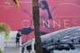 A man works in front of Palais des Festivals, under the official poster of the 70th Cannes Film Festival on May 15, 2017 on the facade of the Palais des Festivals in Cannes, southeastern France.  / AFP PHOTO / ANNE-CHRISTINE POUJOULAT