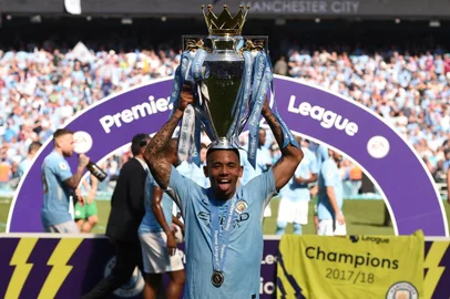 Manchester Citys Brazilian striker Gabriel Jesus holds the Premier League trophy on the pitch after the English Premier League football match between Manchester City and Huddersfield Town at the Etihad Stadium in Manchester, north west England, on May 6, 2018. / AFP PHOTO / Oli SCARFF / RESTRICTED TO EDITORIAL USE. No use with unauthorized audio, video, data, fixture lists, club/league logos or live services. Online in-match use limited to 75 images, no video emulation. No use in betting, games or single club/league/player publications.  / 