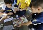 Álbum de figurinhas da Copa é atração no recreio das escolas e une pais e filhos