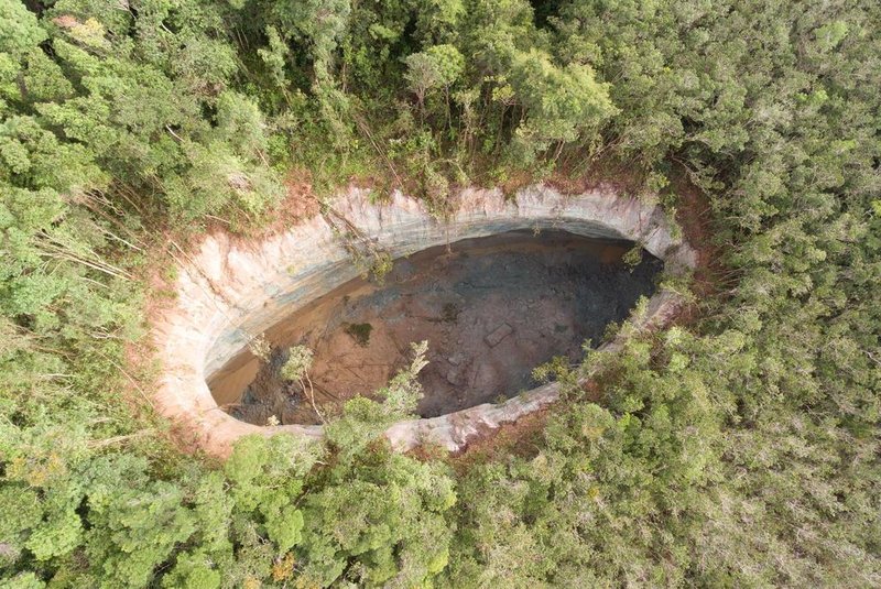 A imagem aérea de uma cratera que se abriu em Matarandiba, na Bahia, impressiona. São 69 metros de comprimento por 29 metros de largura, o que equivale a um terço de um campo de futebol com profundidade de 46 metros. A região fica a cerca de 1 km de uma vila de Vera Cruz, na Ilha de Itaparica e tem sido motivo de preocupação por parte dos moradores. 