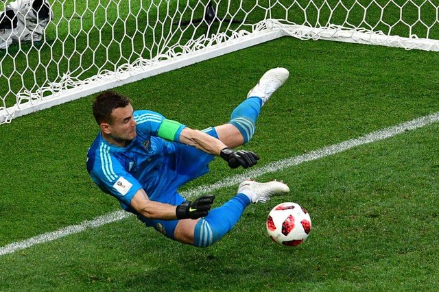 Russias goalkeeper Igor Akinfeev saves the ball kicked by Spains midfielder Koke in a penalty shootout during the Russia 2018 World Cup round of 16 football match between Spain and Russia at the Luzhniki Stadium in Moscow on July 1, 2018. / AFP PHOTO / Mladen ANTONOV / RESTRICTED TO EDITORIAL USE - NO MOBILE PUSH ALERTS/DOWNLOADS Russias goalkeeper Igor Akinfeev saves the ball kicked by Spains midfielder Koke in a penalty shootout during the Russia 2018 World Cup round of 16 football match between Spain and Russia at the Luzhniki Stadium in Moscow on July 1, 2018. / AFP PHOTO / Mladen ANTONOV / RESTRICTED TO EDITORIAL USE - NO MOBILE PUSH ALERTS/DOWNLOADS