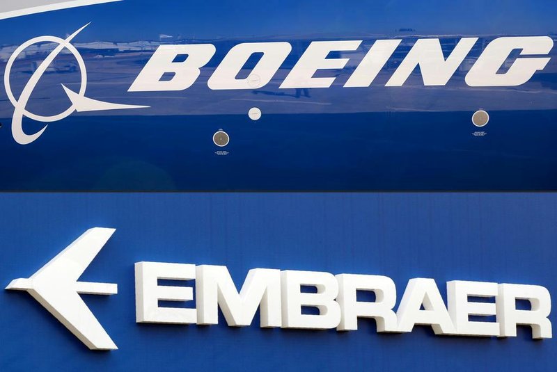 -(FILES) This file photo composition created on December 21, 2017  shows the Boeing logo on the fuselage of a Boeing 787-10 Dreamliner test plane presented on the tarmac of Le Bourget airport near Paris on June 18, 2017, and the logo of Brazil's aircraft manufacturer Embraer also taken at Le Bourget airport, on June 23, 2013.On February 2, 2018 Embraer stocks rose almost 5% on the Sao Paulo Stock Exchange, following the leaking of a possible agreement between the Brazilian aircraft manufacturer and the US company Boeing for the joint development of commercial aircrafts. / AFP PHOTO / ERIC PIERMONTEditoria: FINLocal: Le BourgetIndexador: ERIC PIERMONTSecao: merger, acquisition and takeoverFonte: AFPFotógrafo: STF