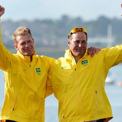 Bronze medalists Brazils Bruno Prada (L) and Robert Scheidt celebrate on the podium of the Star sailing class at the London 2012 Olympic Games, in Weymouth on August 5, 2012.  AFP PHOTO/William WEST