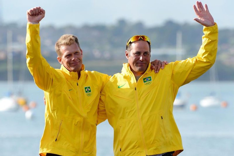 Bronze medalists Brazils Bruno Prada (L) and Robert Scheidt celebrate on the podium of the Star sailing class at the London 2012 Olympic Games, in Weymouth on August 5, 2012.  AFP PHOTO/William WEST