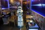This picture taken on December 11, 2017 shows a robot named Mortar delivering drinks to customers at the Robo Cafe, the first establishment to use a robot in Hanoi.The inspiration for the spaceship-themed cafe, which opened recently in the heart of the citys historic district, came after the owners saw a sushi-serving robot in Japan. Mortar delivers drinks and snacks to customers as it moves across the cafe floor via electromagnetic sensors guided by aluminium strips. / AFP PHOTO / HOANG DINH NAM