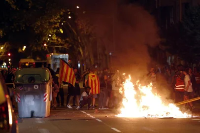 Protesters burn garbage from trash containers after a demonstration held in Barcelona on October 1, 2018 to commemorate the first anniversary of a banned referendum on secession, erupted into riot.A year after a banned referendum on secession from Spain, tens of thousands of Catalan militants piled pressure on the regions separatist government today during an anniversary marked by road and railway line blockades. / AFP PHOTO / Pau Barrena
