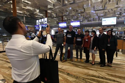 Pier Messaggio (4th-L), Italian eletronics designer poses with other passengers of flight SQ22, Singapore Airlines inaugural non-stop flight to New York with airport staff after checking in at Changi International Airport in Singapore on October 11, 2018. - Passengers were getting ready to board the worlds longest flight on October 11 -- a marathon 19 hours in the air between Singapore and New York. (Photo by ROSLAN RAHMAN / AFP)