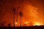 A power line catches fire as the Woolsey fire burns on both sides of Pacific Coast Highway (Highway 1) in Malibu, California, as night falls on November 9, 2018. About 75,000 homes have been evacuated in Los Angeles and Ventura counties due to two fires in the region. 