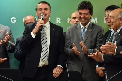 Jair Bolsonaro (esq.) discursa ao anunciar o nome de Luiz Henrique Mandetta (dir.) como novo ministro da Saúde