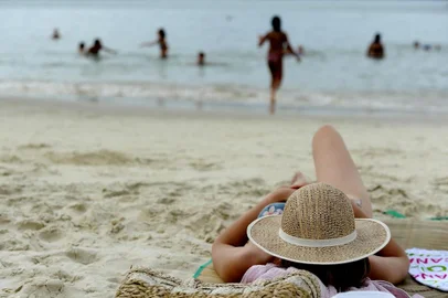  Praia da Daniela. Cuidados com o sol em dias nublados.Nanci Sato, 34 anos, esteticista de São Paulo, (com chapéu no rosto)Indexador: DANIEL CONZI                    