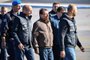  Italian former communist militant Cesare Battisti (C), wanted in Rome for four murders attributed to a far-left group in the 1970s, is escorted by Italian Police officers after stepping off a plane coming from Bolivia and chartered by Italian authorities, after landing at Ciampino airport in Rome on January 14, 2019. - Former communist militant Cesare Battisti landed in Rome on January 14 after an international police squad tracked the Italian down and arrested him in Bolivia, ending almost four decades on the run. (Photo by Alberto PIZZOLI / AFP)Editoria: POLLocal: RomeIndexador: ALBERTO PIZZOLISecao: politics (general)Fonte: AFPFotógrafo: STF