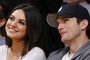Actress Mila Kunis, left, and actor Ashton Kutcher, right, sit courtside together at the N
