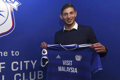  Picture released by Cardiff City FC via Noticias Argentinas, showing Argentine footballer Emiliano Sala posing with Cardiff's jersey after signing for the club, in Cardiff, on January 20, 2019. - Premier League club Cardiff City's record new signing, Argentine striker Emiliano Sala, is missing presumed dead after a light aircraft he was travelling in disappeared over the English Channel on January 21, 2019. Police on the British island of Guernsey have suspended their search for the evening on January 22. Sala was heading to the Welsh capital after saying his final goodbyes to former teammates at French Ligue 1 Nantes. (Photo by HO / NOTICIAS ARGENTINAS / AFP) / - Argentina OUT / RESTRICTED TO EDITORIAL USE - MANDATORY CREDIT "AFP PHOTO / CCFC / NA" - NO MARKETING NO ADVERTISING CAMPAIGNS - DISTRIBUTED AS A SERVICE TO CLIENTSEditoria: SPOLocal: CardiffIndexador: HOSecao: soccerFonte: NOTICIAS ARGENTINASFotógrafo: STR
