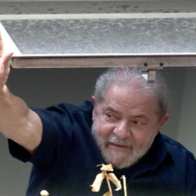  Former Brazilian President Luiz Inacio Lula da Silva (R) waves at supporters from a window of the Workers Party (PT) state headquarters in Sao Paulo, Brazil, on March 4, 2016. Police searched the home of Brazils powerful ex-president Luiz Inacio Lula da Silva and detained him for questioning Friday in a probe into a huge corruption scheme. The detention of Lula da Silva for questioning and the search of his home by officers probing a corruption network amounts to an attack on the rule of law, his spokesman said Friday. AFP PHOTO / NELSON ALMEIDA NELSON ALMEIDA / AFPEditoria: CLJLocal: Sao PauloIndexador: NELSON ALMEIDASecao: policeFonte: AFPFotógrafo: STF