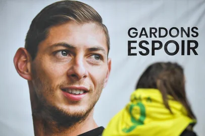 -An FC Nantes supporter stands beside a portrait of Argentinian striker Emiliano Sala prior to a team training session at the training centre La Joneliere in La Chapelle-sur-Erdre, western France, on January 24, 2019, three days after the plane carrying Sala vanished over the English Channel. - Police on January 24 ended their search for new Premier League player Emiliano Sala, saying the chances of finding the Argentine alive three days after his plane went missing over the Channel were extremely remote. Sala, 28, was on his way from Nantes in western France to the Welsh capital to train with his new teammates for the first time after completing a £15 million ($19 million) move to Cardiff City from French side Nantes on January 19. (Photo by LOIC VENANCE / AFP)Editoria: DISLocal: La Chapelle-sur-ErdreIndexador: LOIC VENANCESecao: soccerFonte: AFPFotógrafo: STF