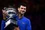  Serbias Novak Djokovic celebrates with the championship trophy during the presentation ceremony after his victory against Spains Rafael Nadal in the mens singles final on day 14 of the Australian Open tennis tournament in Melbourne on January 27, 2019. (Photo by Saeed KHAN / AFP) / -- IMAGE RESTRICTED TO EDITORIAL USE - STRICTLY NO COMMERCIAL USE --Editoria: SPOLocal: MelbourneIndexador: SAEED KHANSecao: tennisFonte: AFPFotógrafo: STF
