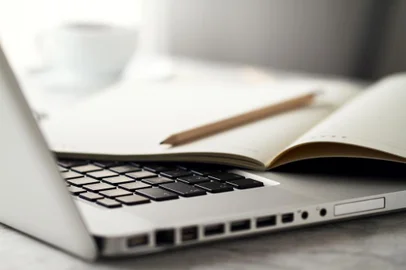 Closeup of Workspace with Modern Creative Laptop, Cup of Coffee and Pencils. Horizontal with Copy Space. 