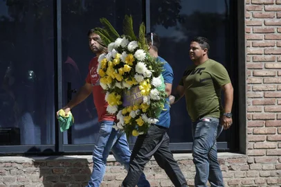 People carrying a wreath arrive at the Club Atletico y Social San Martin to attend the wake of late Argentine football player Emiliano Sala, in Progreso in Santa Fe province, Argentina on February 16, 2019. - Sala was flying to his new team, English Premier League side Cardiff City, from his old French club Nantes when his plane went missing on January 21. A public vigil was held in a gymnasium in Progreso, the modest village in the province of Santa Fe which Sala left as a teenager to forge a career in Europe. (Photo by Juan Mabromata / AFP)