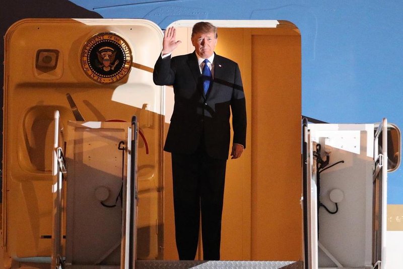 US President Donald Trump waves after arriving at Noi Bai airport for the US-DPRK summit in Hanoi on February 26, 2019. - North Korean leader Kim Jong Un and US President Donald Trump arrived in Hanoi on February 26, ahead of a second summit closely watched for concrete steps to dismantle Pyongyangs nuclear programme. (Photo by KHAM / POOL / AFP)