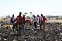 Red cross team work amid debris at the crash site of Ethiopia Airlines near Bishoftu, a town some 60 kilometres southeast of Addis Ababa, Ethiopia, on March 10, 2019. - An Ethiopian Airlines Boeing 737 crashed on March 10 morning en route from Addis Ababa to Nairobi with 149 passengers and eight crew believed to be on board, Ethiopian Airlines said. (Photo by Michael TEWELDE / AFP)