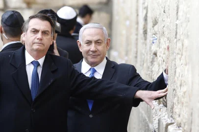 Brazilian President Jair Bolsonaro (foreground) and Israeli Prime Minister Benjamin Netanyahu (background) pray at the Western wall, the holiest site where Jews can pray, in the Old City of Jerusalem on April 1, 2019. - Bolsonaro visited the Western Wall alongside Netanyahu on Monday, becoming the first head of state to do so with an Israeli premier. The site, one of the holiest in Judaism, is located in east Jerusalem, occupied by Israel in the 1967 Six-Day War and later annexed in a move never recognised by the international community. (Photo by Menahem KAHANA / POOL / AFP)