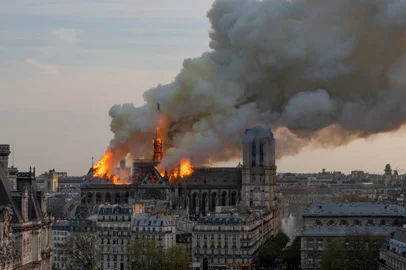 Smoke billows as flames burn through the roof of the Notre-Dame de Paris Cathedral on April 15, 2019, in the French capital Paris. - A huge fire swept through the roof of the famed Notre-Dame Cathedral in central Paris on April 15, 2019, sending flames and huge clouds of grey smoke billowing into the sky. The flames and smoke plumed from the spire and roof of the gothic cathedral, visited by millions of people a year. A spokesman for the cathedral told AFP that the wooden structure supporting the roof was being gutted by the blaze. (Photo by Fabien Barrau / AFP)