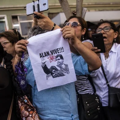 Supporters of late Peruvian ex-president Alan Garcia react during his funeral procession in Lima, on April 19, 2019. - Garcia, who was president from 1985-90 and again from 2006-11, died in hospital on Wednesday after shooting himself in the head at his home as police were about to arrest him over the graft investigation. He was suspected of having taken bribes from Brazilian construction giant Odebrecht in return for large-scale public works contracts. (Photo by ERNESTO BENAVIDES / AFP)