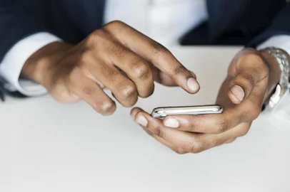 homem teclando em um celular