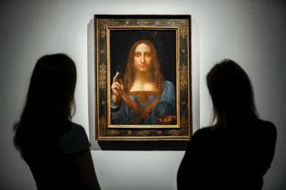 (FILES) In this file photo taken on October 24, 2017 Christies employees pose in front of a painting entitled Salvator Mundi by Italian polymath Leonardo da Vinci at a photocall at Christies auction house in central London ahead of its sale at Christies New York on November 15, 2017. - Later this year, the Louvre museum in Paris will host an exhibition grouping masterpieces of the great Italian painter Leonardo da Vinci to mark his death 500 years ago in France.The Salvator Mundi, sold at auction as a work by Leonardo for a record $450 million dollars in 2017, has not been displayed in public since, as doubts swirl about its ownership, whereabouts and authenticity. (Photo by Tolga Akmen / AFP) / RESTRICTED TO EDITORIAL USE - MANDATORY MENTION OF THE ARTIST UPON PUBLICATION - TO ILLUSTRATE THE EVENT AS SPECIFIED IN THE CAPTION