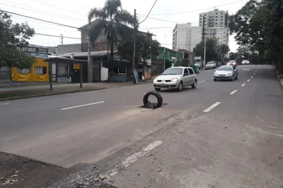 Motoristas que circulam pela Rua Assis Brasil, no bairro Jardelino Ramos, em Caxias do Sul, devem redobrar a atenção: um pneu sustentando por uma pedra alerta para um buraco no meio da pista, próximo à esquina com a Rua Humberto de Campos. 