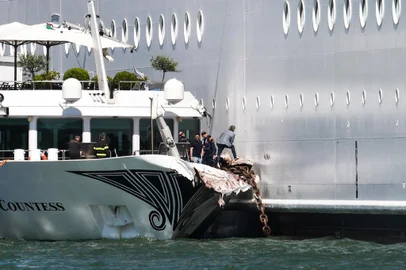 The damaged River Countess tourist boat is pictured after it was hit early on June 2, 2019 by the MSC Opera cruise ship (R) that lost control as it was coming in to dock in Venice, Italy. - Tourists on land could be seen running away as the MSC Opera scraped along the dockside, its engine blaring, before knocking into the River Countess tourist boat. (Photo by Andrea PATTARO / AFP)