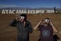  Tourists try special glasses to watch an eclipse at the entrance of an astronomical camp which expects to receive thousands of tourists to observe the July 2 total solar eclipse, in the commune of Vallenar in the Atacama desert about 600 km north of Santiago, on July 1, 2019. - A total solar eclipse will be visible from small parts of Chile and Argentina on July 2. (Photo by MARTIN BERNETTI / AFP)Editoria: SCILocal: VallenarIndexador: MARTIN BERNETTISecao: natural scienceFonte: AFPFotógrafo: STF