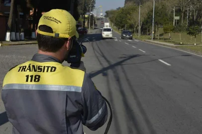 Agente de trânsito na perimetral norte em Caxias com radar móvel.