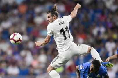 Real Madrids Welsh forward Gareth Bale (L) challenges Getafes Uruguayan defender Damian Suarez during the Spanish League football match between Real Madrid and Getafe at the Santiago Bernabeu stadium in Madrid on August 19, 2018. / AFP PHOTO / JAVIER SORIANO