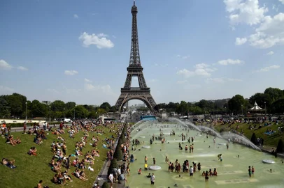  People cool off and sunbathe by the Trocadero Fountains next to the Eiffel Tower in Paris, on July 25, 2019 as a new heatwave hits the French capital. - After all-time temperature records were smashed in Belgium, Germany and the Netherlands on July 24, Britain and the French capital Paris could on July 25 to see their highest ever temperatures. (Photo by Bertrand GUAY / AFP)Editoria: WEALocal: ParisIndexador: BERTRAND GUAYSecao: reportFonte: AFPFotógrafo: STF