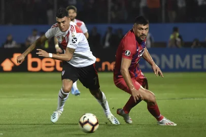 Argentinas River Plate Player Federico Carrizo (L) and Paraguays Cerro Porteno Juan Patino vie for the ball during a Copa Libertadores football match at Pablo Rojas stadium  in Asuncion, on August 29, 2019. (Photo by NORBERTO DUARTE / AFP)