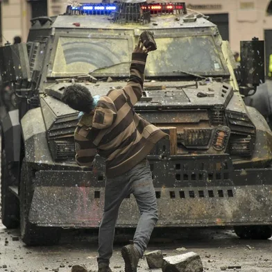 A demonstrator clashes with riot police during a transport strike against the economic policies of the government of Ecuadorean President Lenin Moreno regarding the agreement signed on March with the International Monetary Fund (IMF), in Quito, on October 3, 2019. - The Ecuadorean government confirmed possible labour and tax reforms as established in the agreement, Economy Minister Richard Martinez stated -a day after announcing the elimination of fuel subsidies. (Photo by Rodrigo BUENDIA / AFP)
