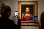 People take pictures with mobile phone at an oil painting by Leonardo da Vincis   Salvator Mundi, during the opening of the exhibition  Leonardo da Vinci , on October 22, 2019 at the Louvre museum in Paris. - Five hundred years after the death of Leonardo da Vinci, the Louvre Museum inaugurates on October 23, 2019 the largest exhibition ever set up around the work of the genius of the Renaissance, which is already announced as a popular success. (Photo by FRANCOIS GUILLOT / AFP) / RESTRICTED TO EDITORIAL USE - MANDATORY MENTION OF THE ARTIST UPON PUBLICATION - TO ILLUSTRATE THE EVENT AS SPECIFIED IN THE CAPTION