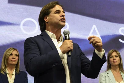 Data: 27/10/2019The presidential candidate for Uruguay's Partido Nacional party, Luis Lacalle Pou gestures flanked by his wife Lorena Ponce de Leon (R) and his vice-presidential candidate Beatriz Argimon, while addressing supporters in Montevideo after polls closed in the country's general election on October 27, 2019. - The leftist ruling coalition's presidential candidate Daniel Martinez was ahead in Uruguay's general election, according to early results, but is set for a run-off on November 24 against former senator Luis Lacalle Pou of the National Party, who was running second with 30 percent. (Photo by EITAN ABRAMOVICH / AFP)